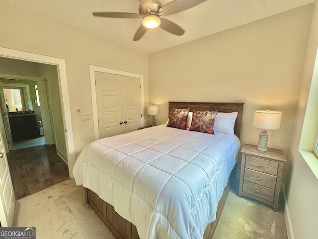 carpeted bedroom with ceiling fan, baseboards, and a closet