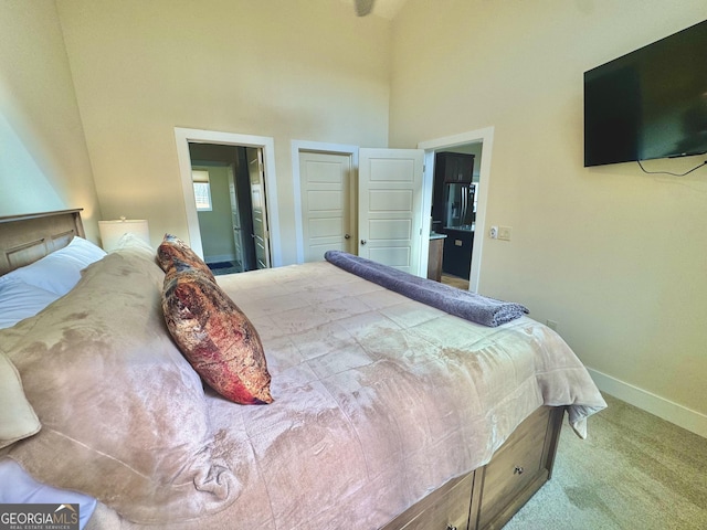 bedroom with carpet flooring, a towering ceiling, and baseboards