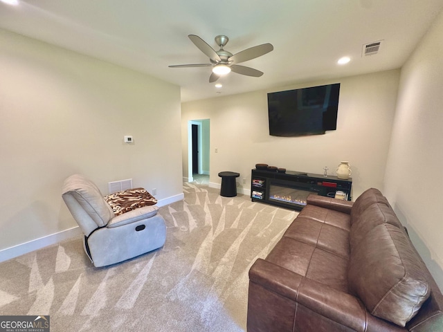 carpeted living room with baseboards, visible vents, and a glass covered fireplace