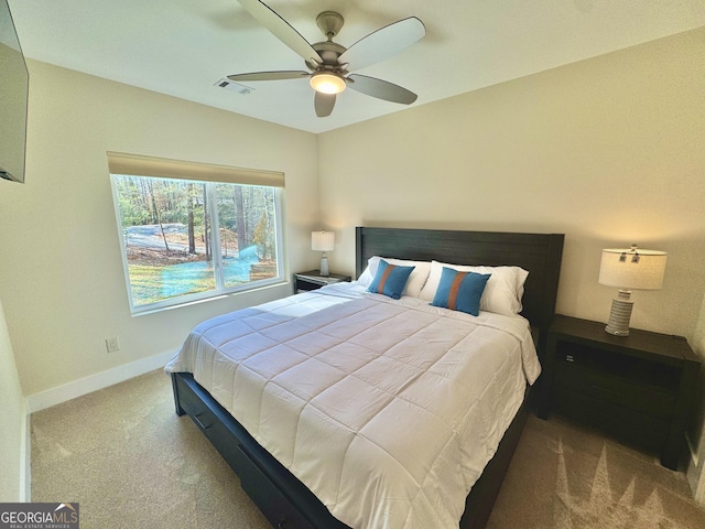 carpeted bedroom featuring baseboards, visible vents, and a ceiling fan