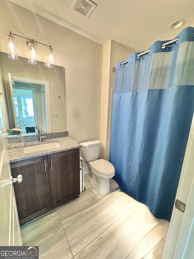 full bath featuring visible vents, a shower with shower curtain, toilet, ensuite bathroom, and vanity