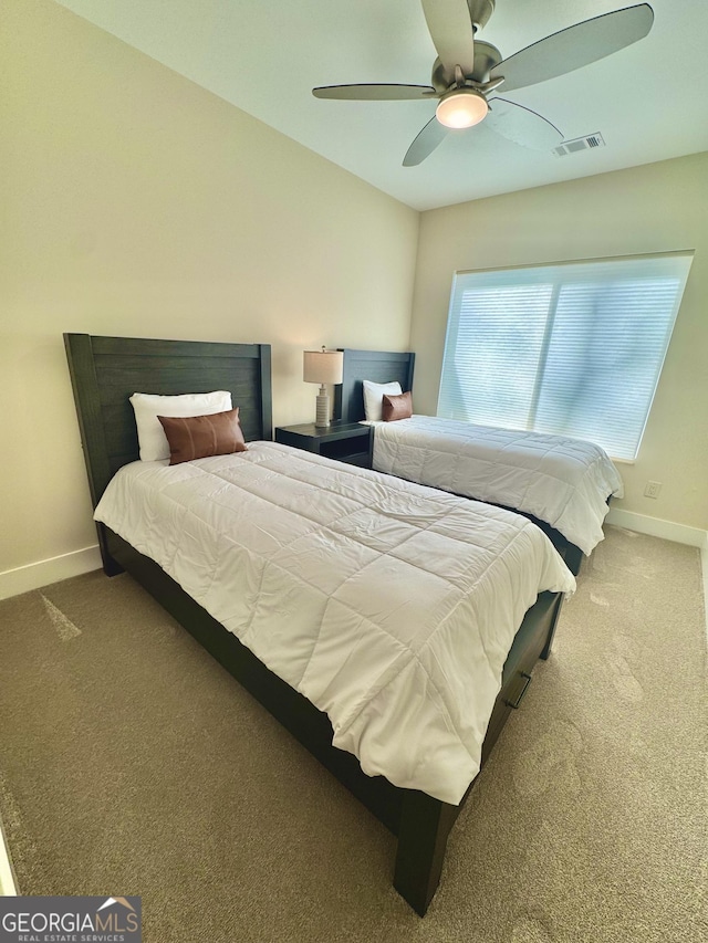 carpeted bedroom featuring baseboards, visible vents, and a ceiling fan