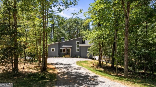 view of front of house with driveway and a chimney