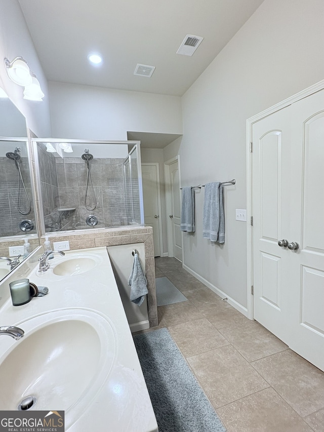 bathroom with a shower with shower door, vanity, and tile patterned flooring