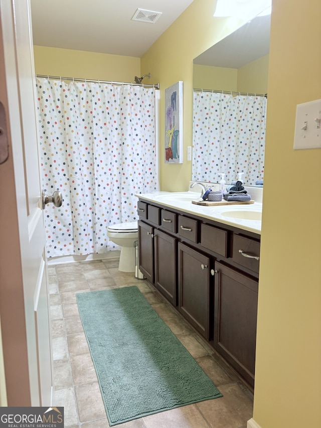 bathroom with curtained shower, toilet, and vanity