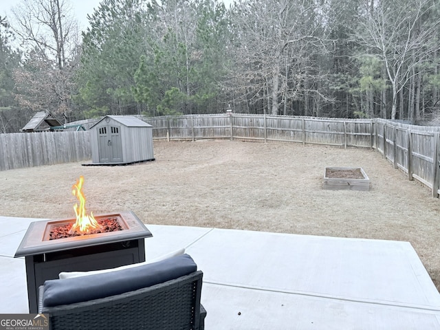 view of patio featuring an outdoor fire pit and a storage shed