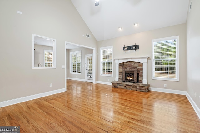 unfurnished living room with a healthy amount of sunlight, light wood-type flooring, a fireplace, and visible vents