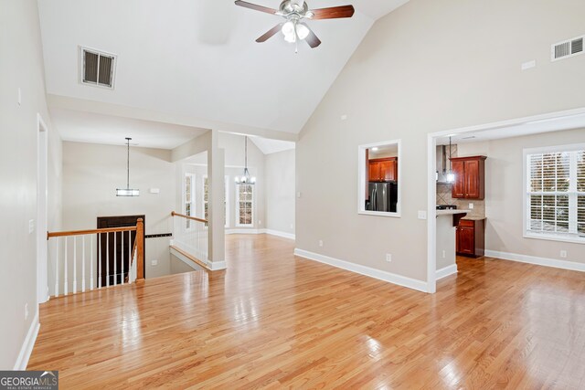 unfurnished room featuring light wood-style flooring, visible vents, and baseboards