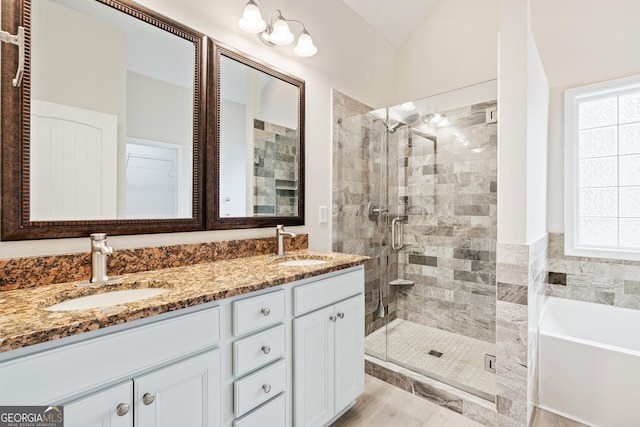 full bathroom with a stall shower, a garden tub, a sink, and double vanity