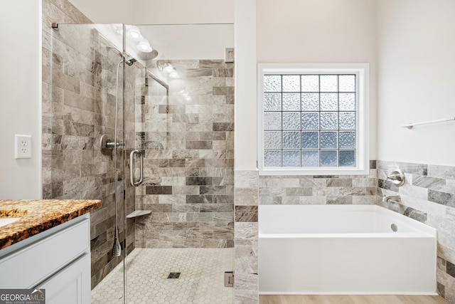 full bath featuring a shower stall, a bath, and vanity