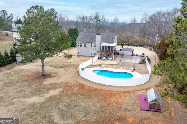 view of swimming pool featuring a sunroom, a patio area, and a fenced backyard