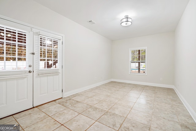 interior space with light tile patterned floors, visible vents, and baseboards