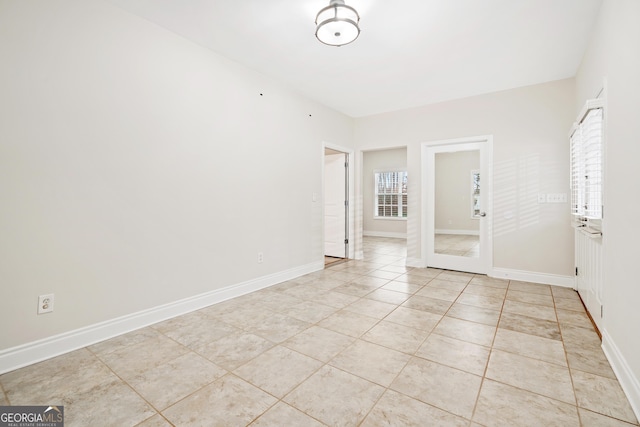 unfurnished room with baseboards and light tile patterned floors