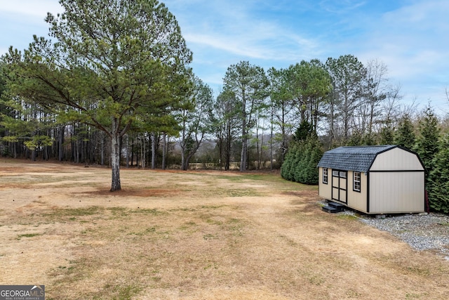 view of yard featuring a storage shed and an outbuilding