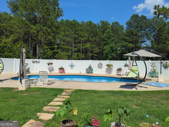 view of swimming pool featuring a fenced in pool, a fenced backyard, a lawn, and a patio