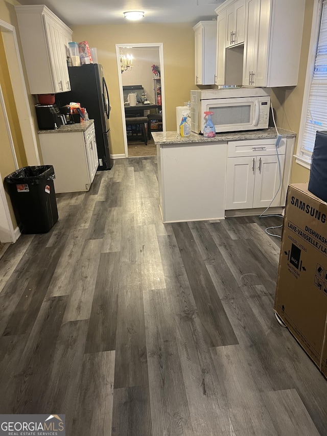 kitchen with white cabinets, dark wood-type flooring, and light stone countertops