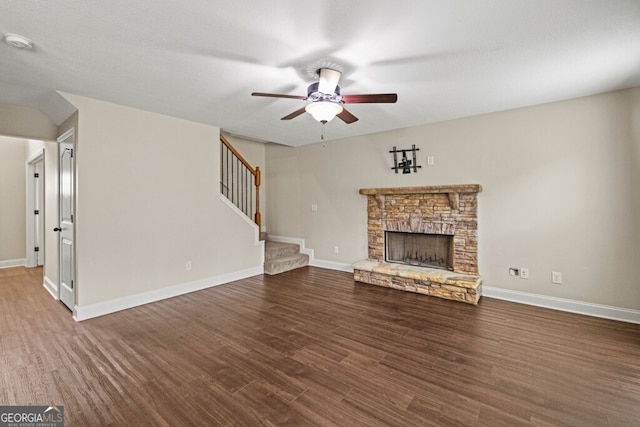 unfurnished living room featuring ceiling fan, dark hardwood / wood-style floors, and a fireplace