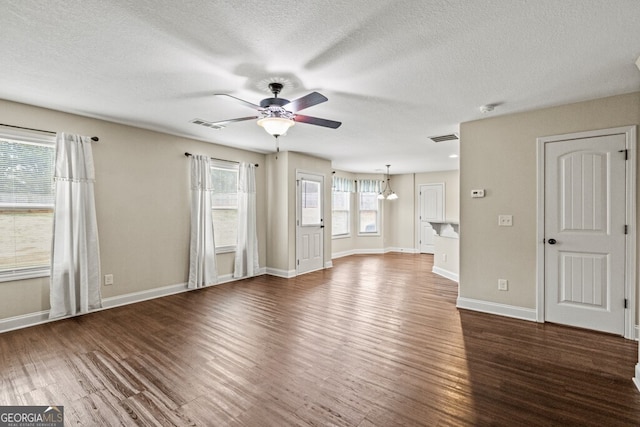 unfurnished living room featuring ceiling fan, dark wood-type flooring, and a textured ceiling