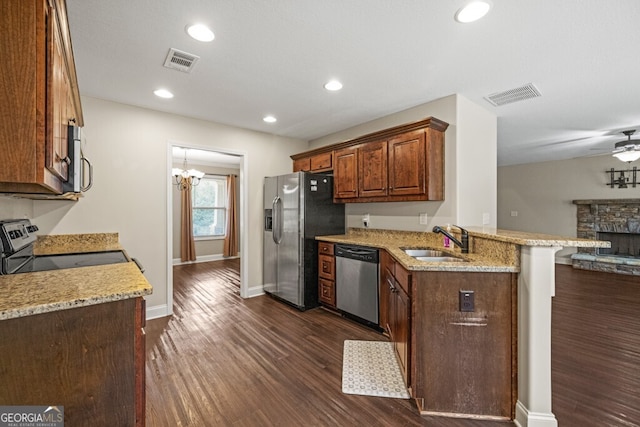 kitchen featuring kitchen peninsula, sink, light stone countertops, a breakfast bar area, and stainless steel appliances