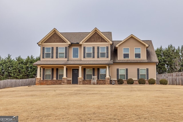 craftsman inspired home featuring covered porch and a front yard