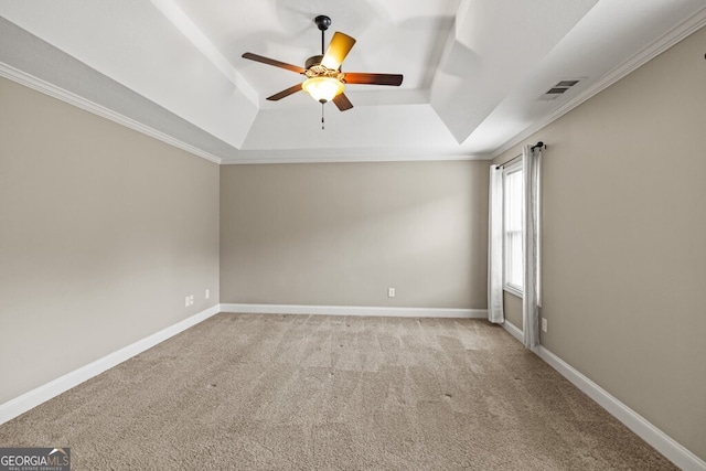 carpeted empty room with ceiling fan, a tray ceiling, and crown molding