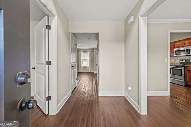 hall featuring ornamental molding and dark wood-type flooring