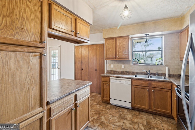 kitchen with pendant lighting, dishwasher, sink, electric range, and a textured ceiling