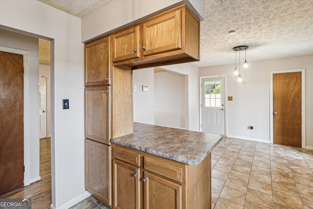 kitchen with decorative light fixtures, kitchen peninsula, and a textured ceiling