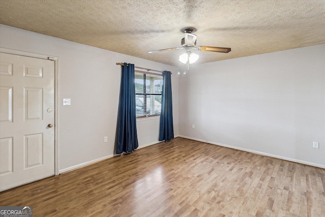 spare room with hardwood / wood-style flooring, a textured ceiling, and ceiling fan