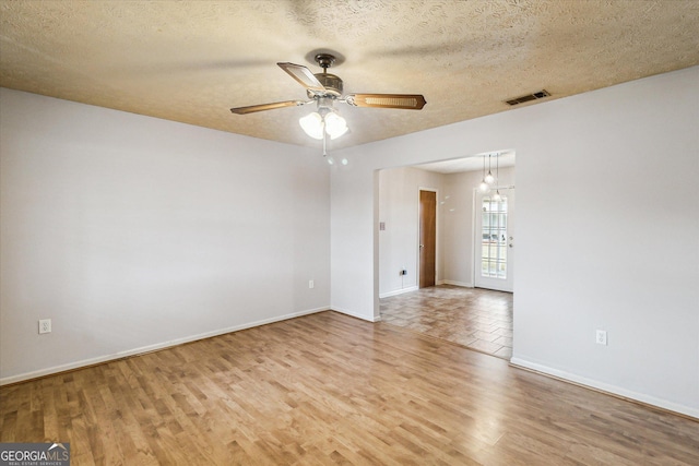 spare room featuring ceiling fan, light hardwood / wood-style flooring, and a textured ceiling