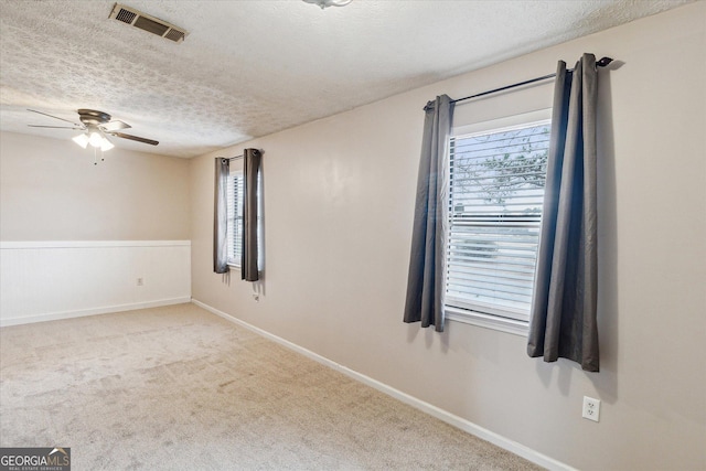 carpeted empty room featuring ceiling fan and a textured ceiling