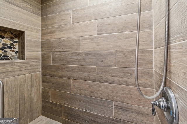 interior details featuring tiled shower