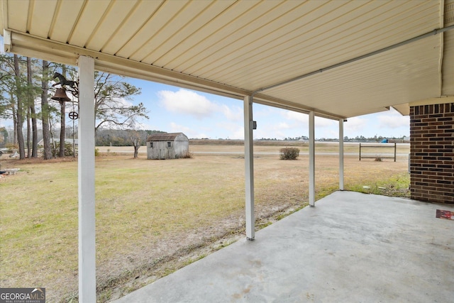 view of patio featuring a rural view and a storage unit