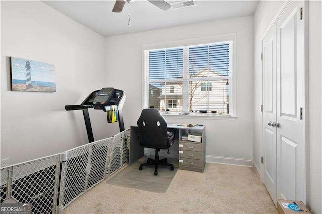 office featuring a ceiling fan, light carpet, visible vents, and baseboards