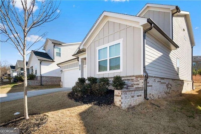 view of side of home featuring driveway, board and batten siding, and an attached garage