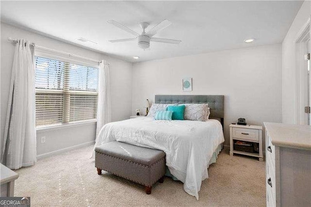 bedroom with a ceiling fan, light carpet, visible vents, and baseboards