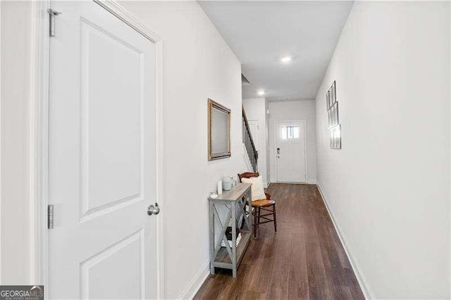 corridor with dark wood-style floors and baseboards