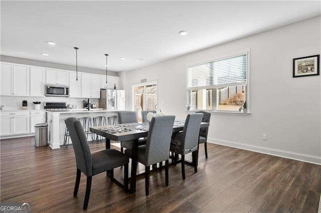 dining room with recessed lighting, dark wood finished floors, and baseboards