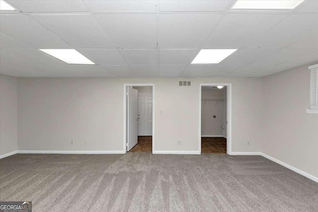 spare room featuring carpet flooring and a drop ceiling