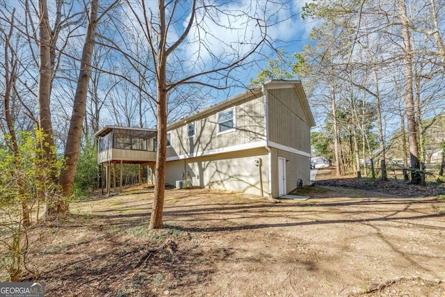 back of property with a sunroom and central AC