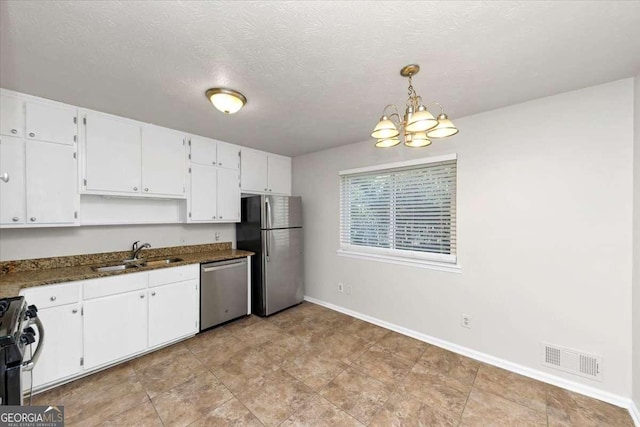 kitchen with a textured ceiling, white cabinetry, hanging light fixtures, sink, and stainless steel appliances