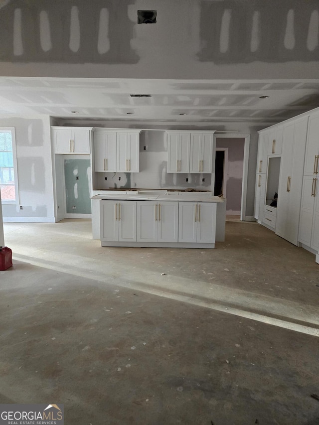 kitchen with concrete floors and white cabinetry