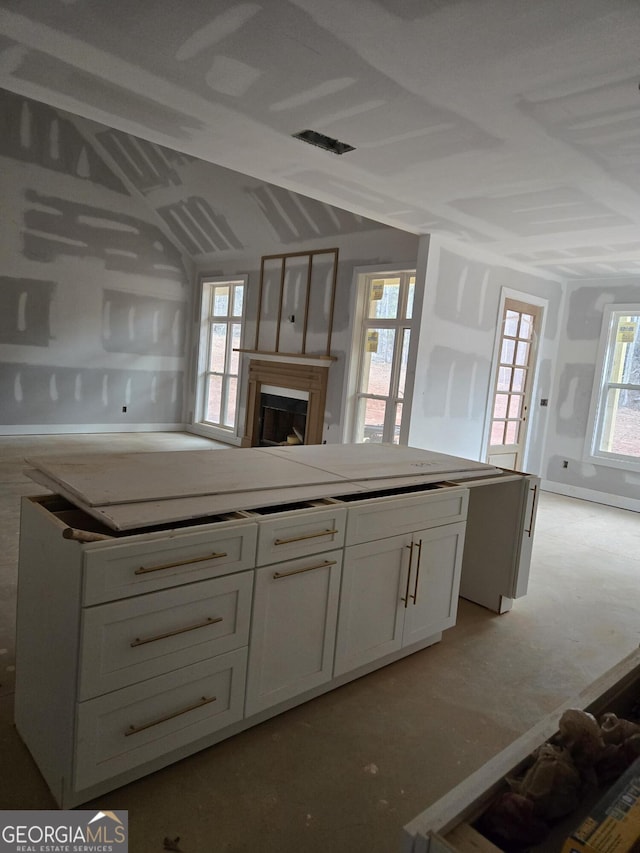 kitchen featuring a fireplace and white cabinetry