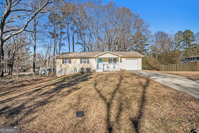 ranch-style home featuring a garage, a front yard, and covered porch