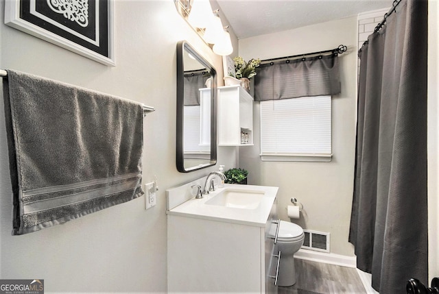 bathroom featuring vanity, toilet, and hardwood / wood-style floors