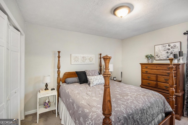 bedroom with a textured ceiling, a closet, and carpet flooring