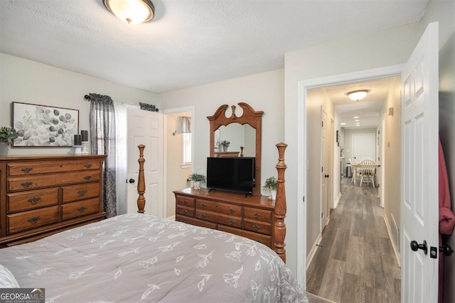 bedroom featuring a textured ceiling and wood-type flooring