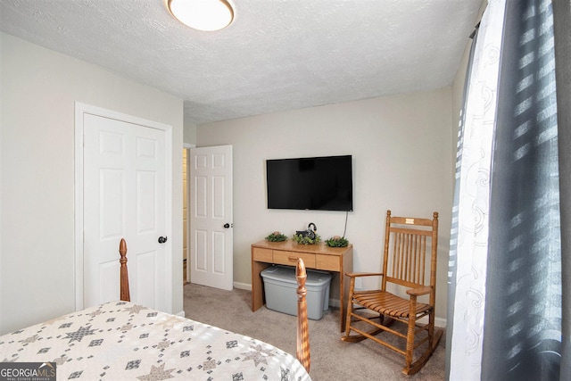 bedroom featuring light colored carpet and a textured ceiling