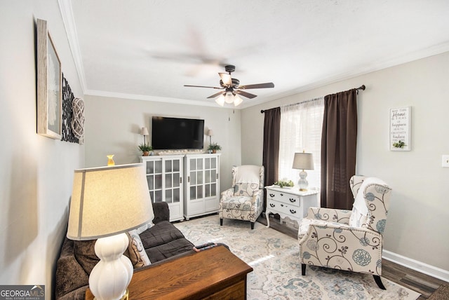 sitting room with crown molding, hardwood / wood-style flooring, and ceiling fan