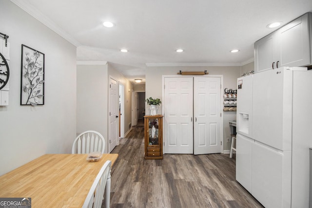 kitchen featuring white fridge with ice dispenser, white cabinets, dark hardwood / wood-style flooring, and crown molding